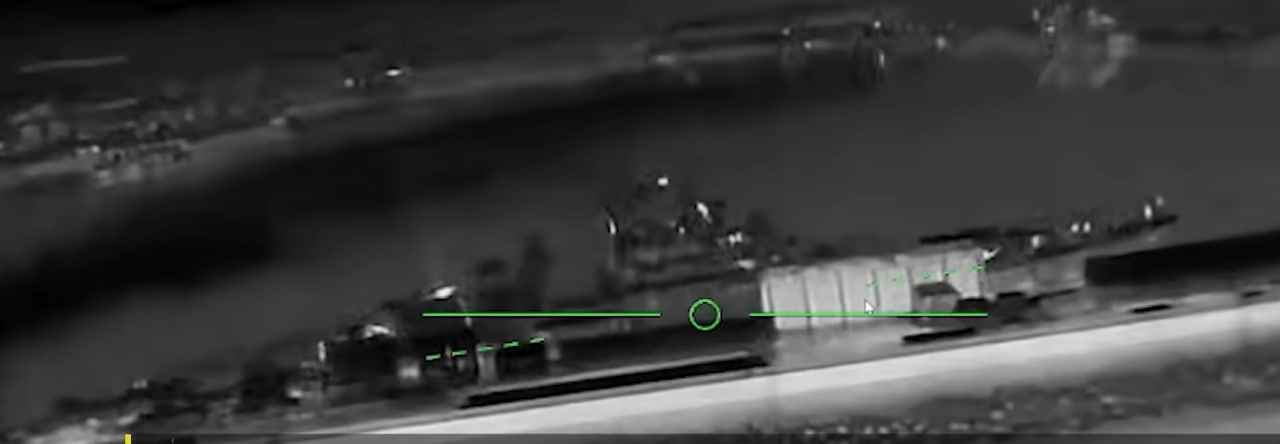 Night-time drone camera frame showing a frigate at a pier in Novorossiysk with a targeting reticle overlaid